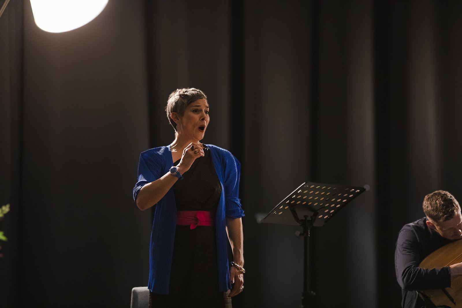 Anna Dennis singing in a blue jacket