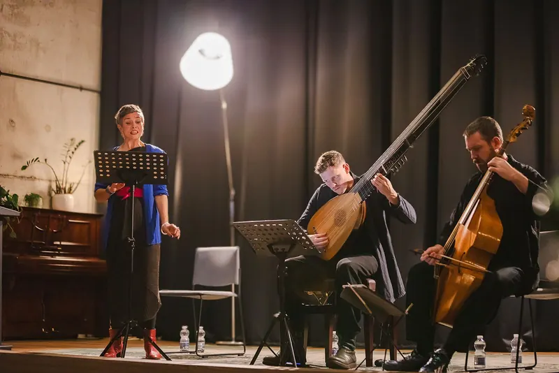 Anna Dennis, Jonas Nordberg and Liam Byrne performing together at 1 Windmill Lane, a standing lamp glowing behind them