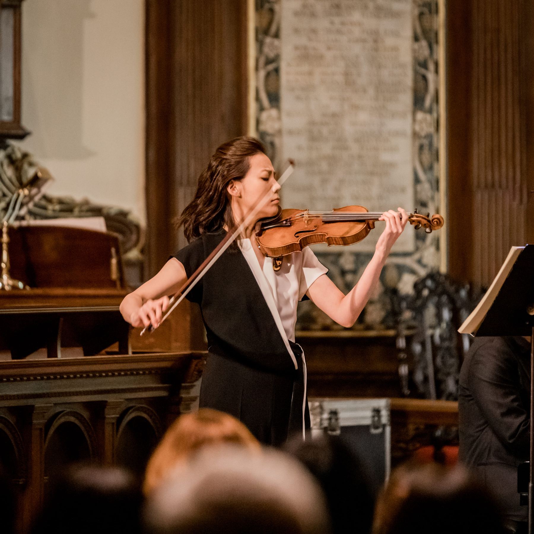 Clara-Jumi Kang playing violin beneath the memorial tablets of St Ann's Church