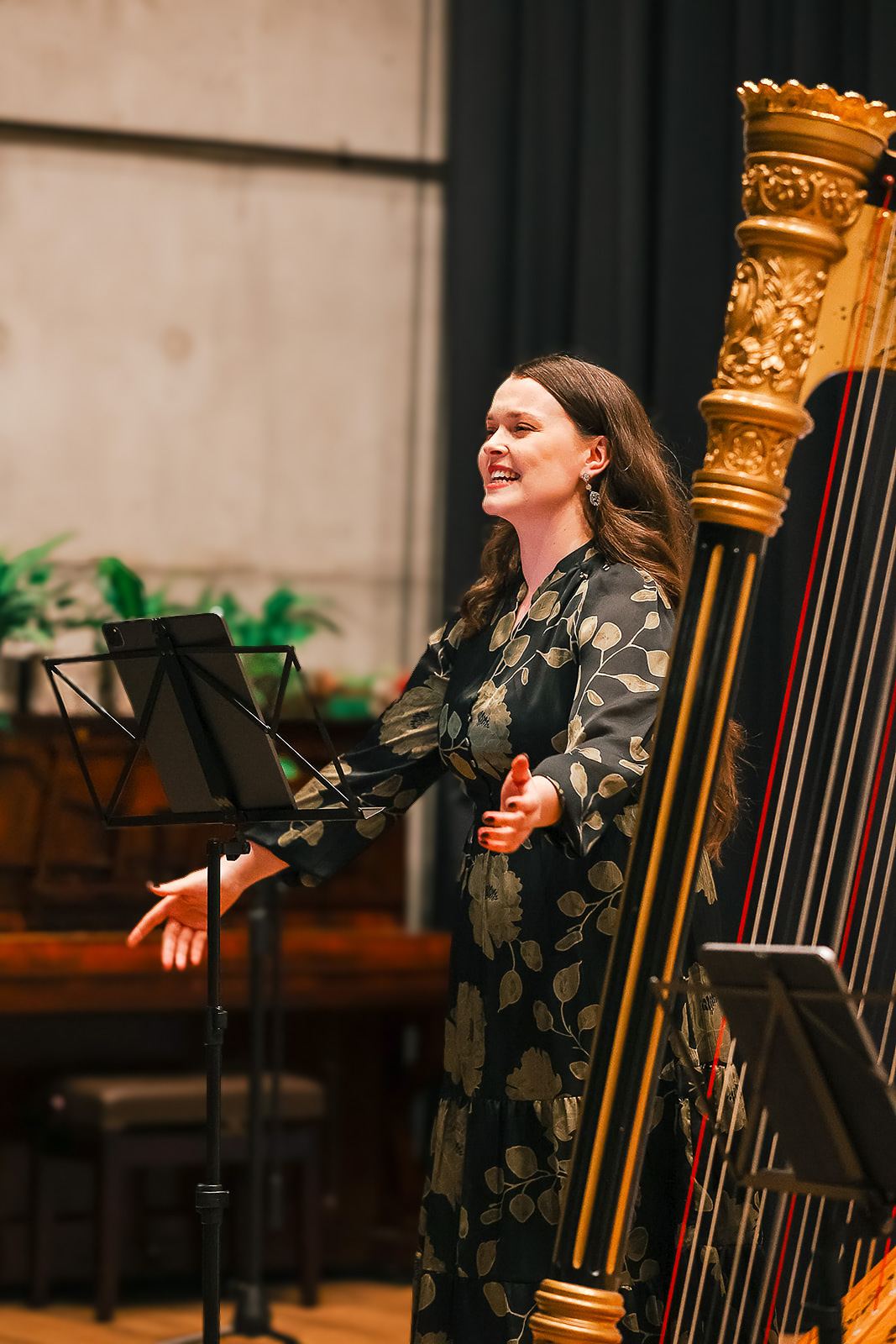 Sarah Shine singing beside the harp