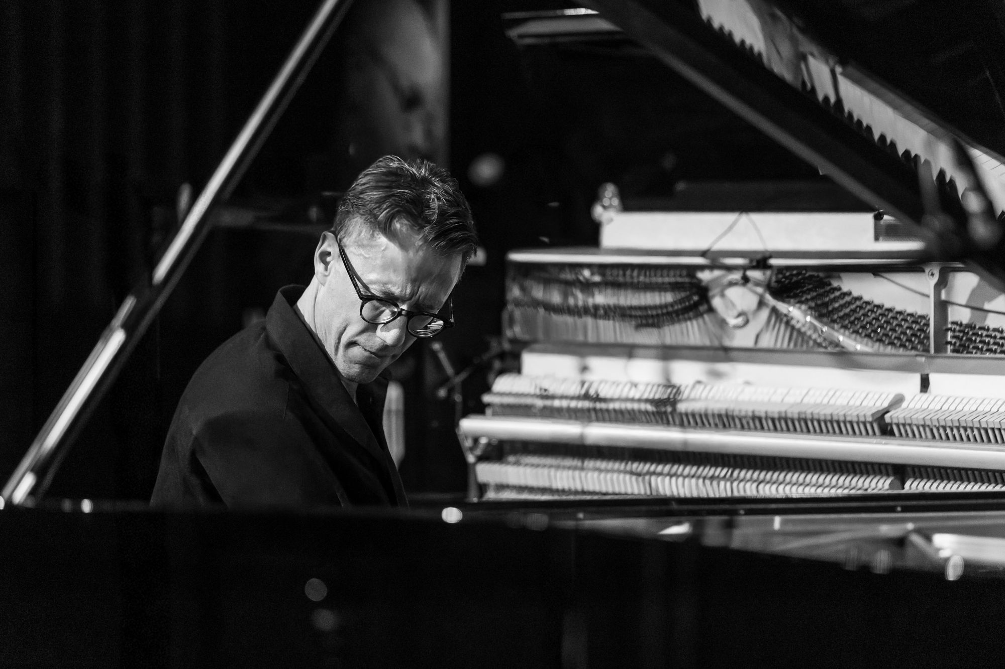 Black and white: Bill Laurance at the keys, framed by the grand's lid with the upright's hammers behind