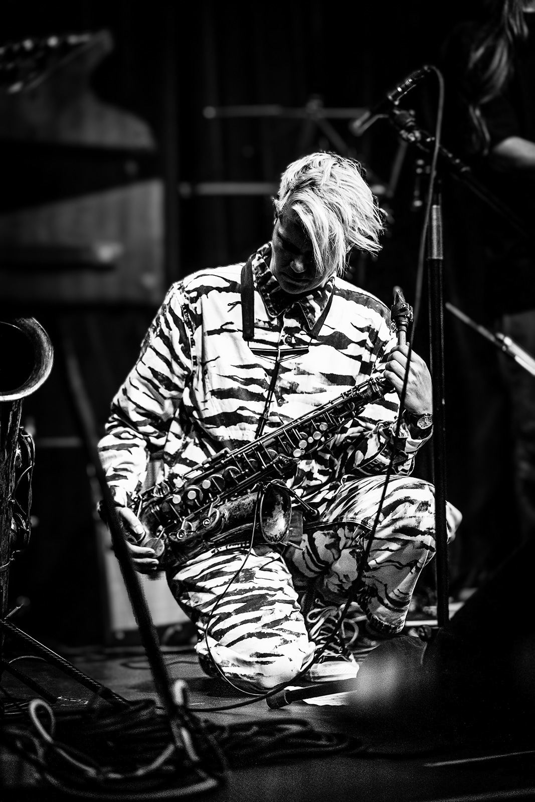 Black and white: Linda Fredriksson kneeling on the stage with the saxophone