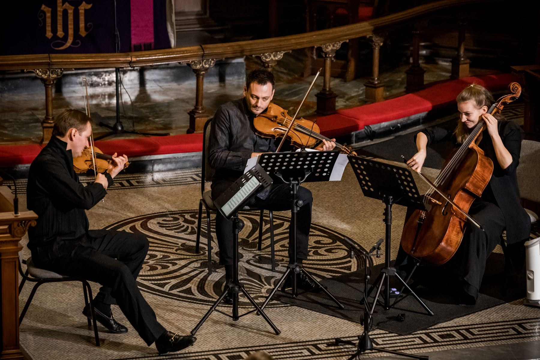 The three players from the side, the curved altar rail behind them