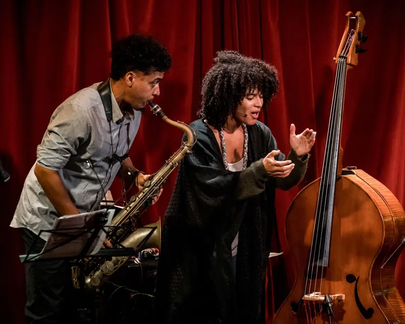 Sélène Saint-Aimé singing beside her double bass as Rafael Aguila plays saxophone