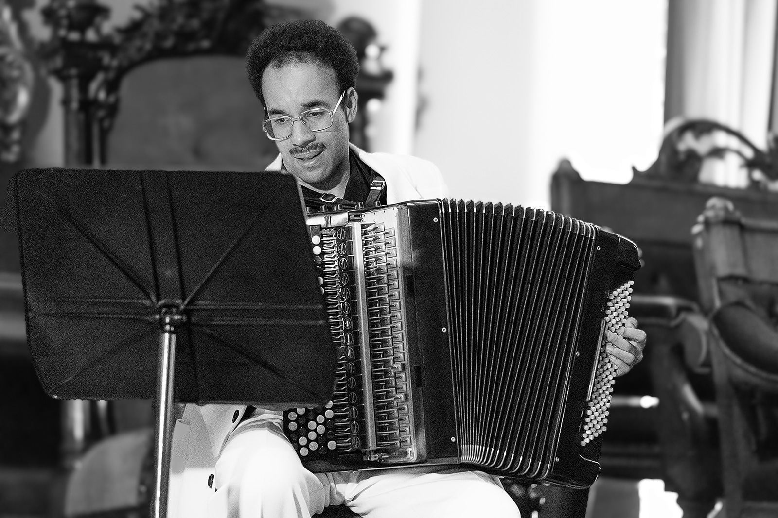 Black and white: Théo Ould playing, a carved chair behind him