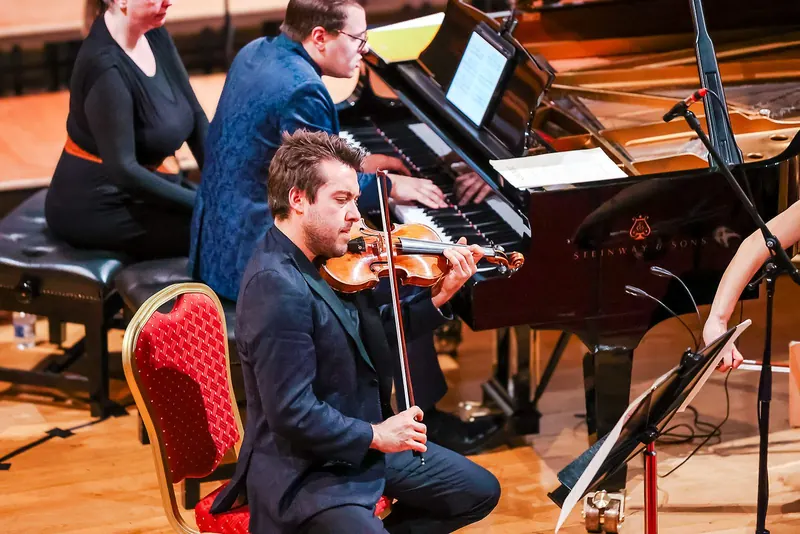 Trio Bohémo's violinist and pianist in performance, a page-turner seated beside the piano