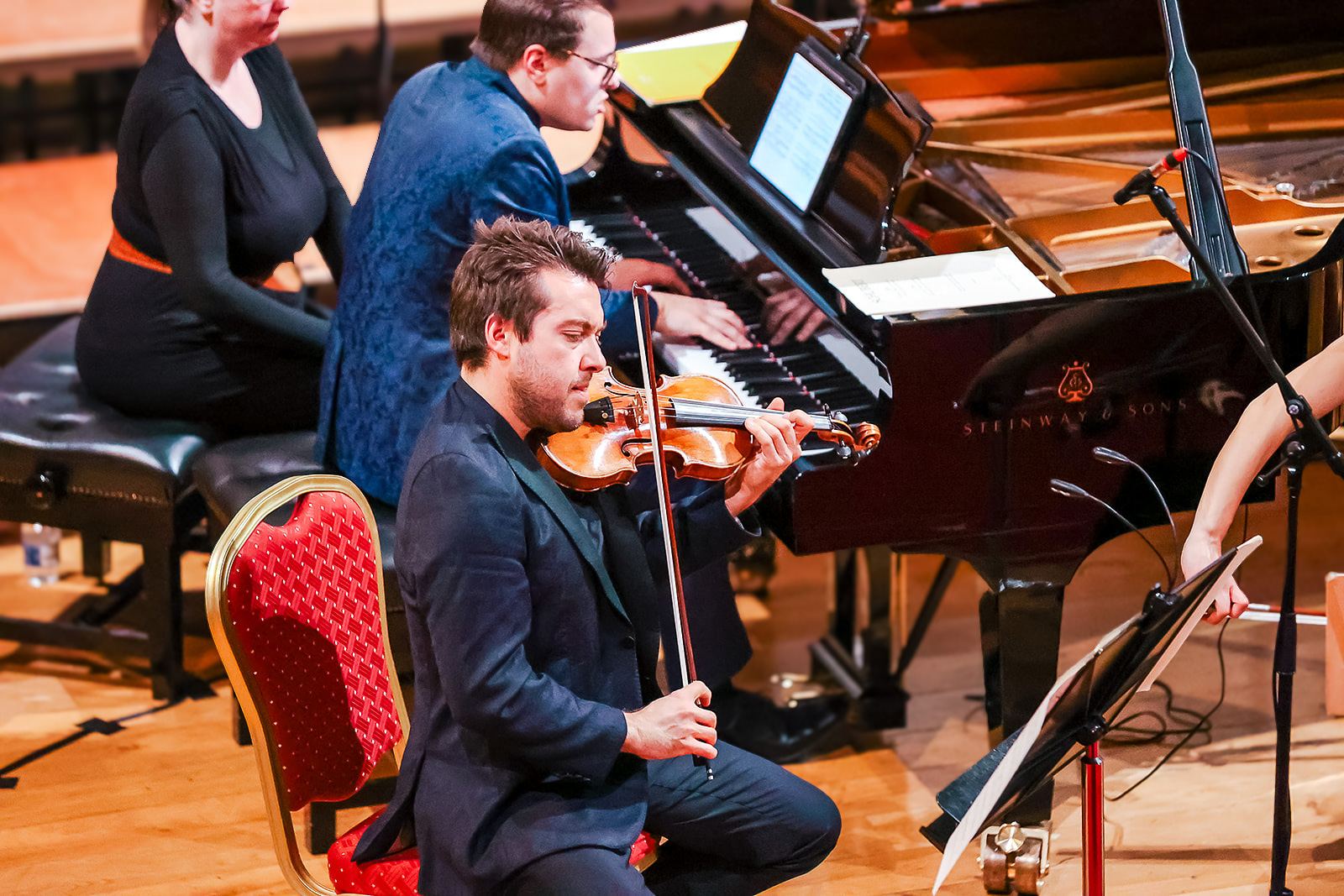 Trio Bohémo's violinist and pianist in performance, a page-turner seated beside the piano
